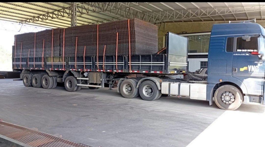 Carreta sendo carregada com painéis de tela soldada no galpão